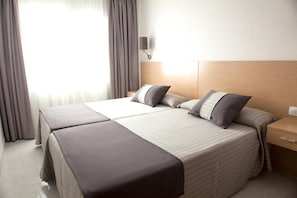A hotel room with a large bed, two bedside tables, a nightstand, and a wall-mounted lamp. - Acuazul Hotel (Peniscola)