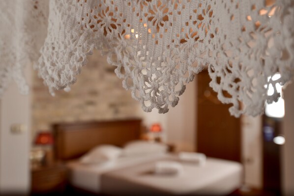 A close-up of a white, intricately designed hanging decoration in a hotel room. - Hotel Kalemi 2 (Gjirokastër)