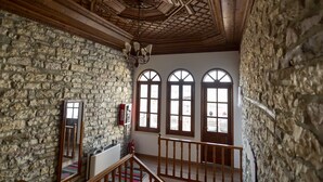 Una habitación con paredes de piedra, vigas de madera y ventanas de arco.