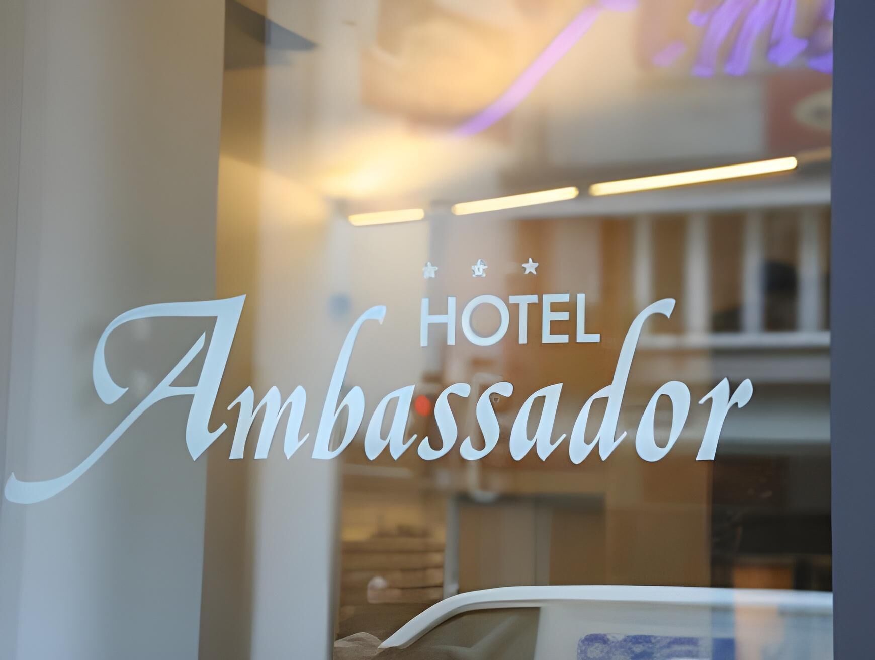 A hotel sign with the name 'Ambassador' and a star rating symbol.
