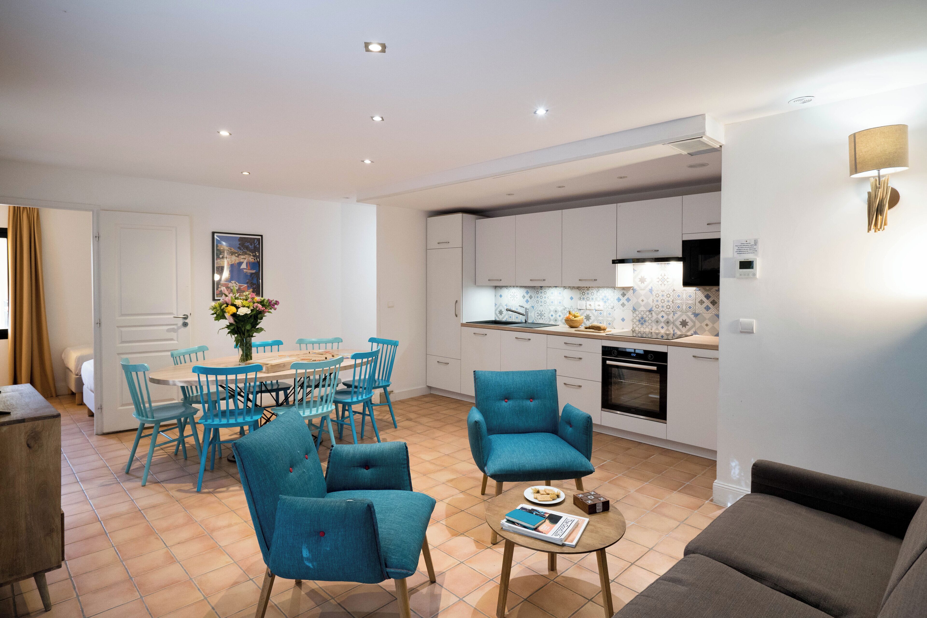 A modern apartment with a dining area, kitchen, and living room.