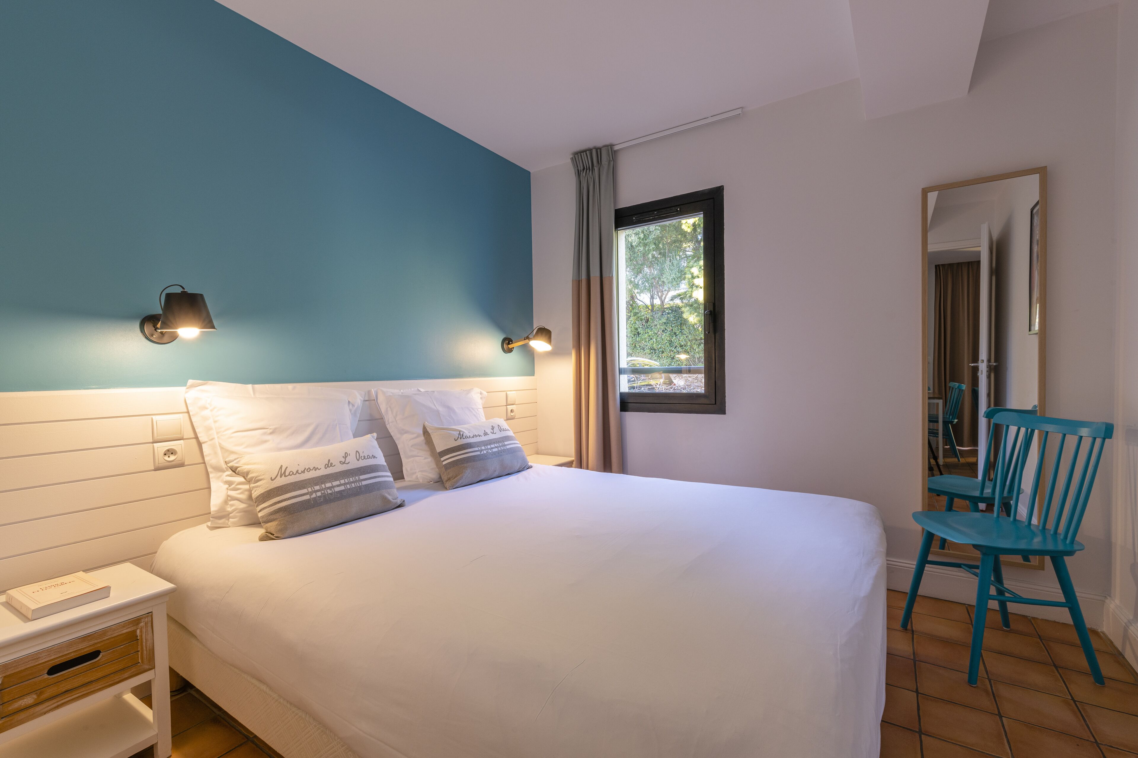 A bedroom with a bed, nightstand, and a chair.