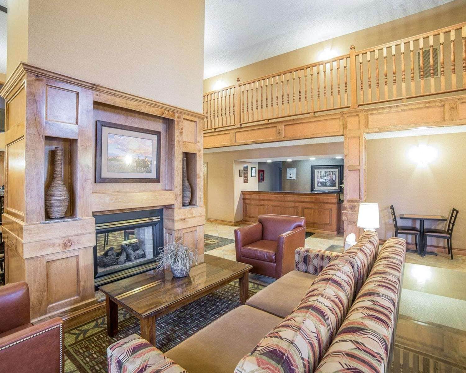 A spacious lobby with a fireplace, seating area, and a staircase.