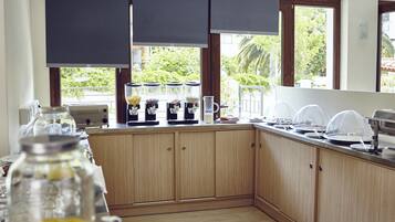 Une cuisine avec des meubles en bois, un coin café et une vue sur la verdure.