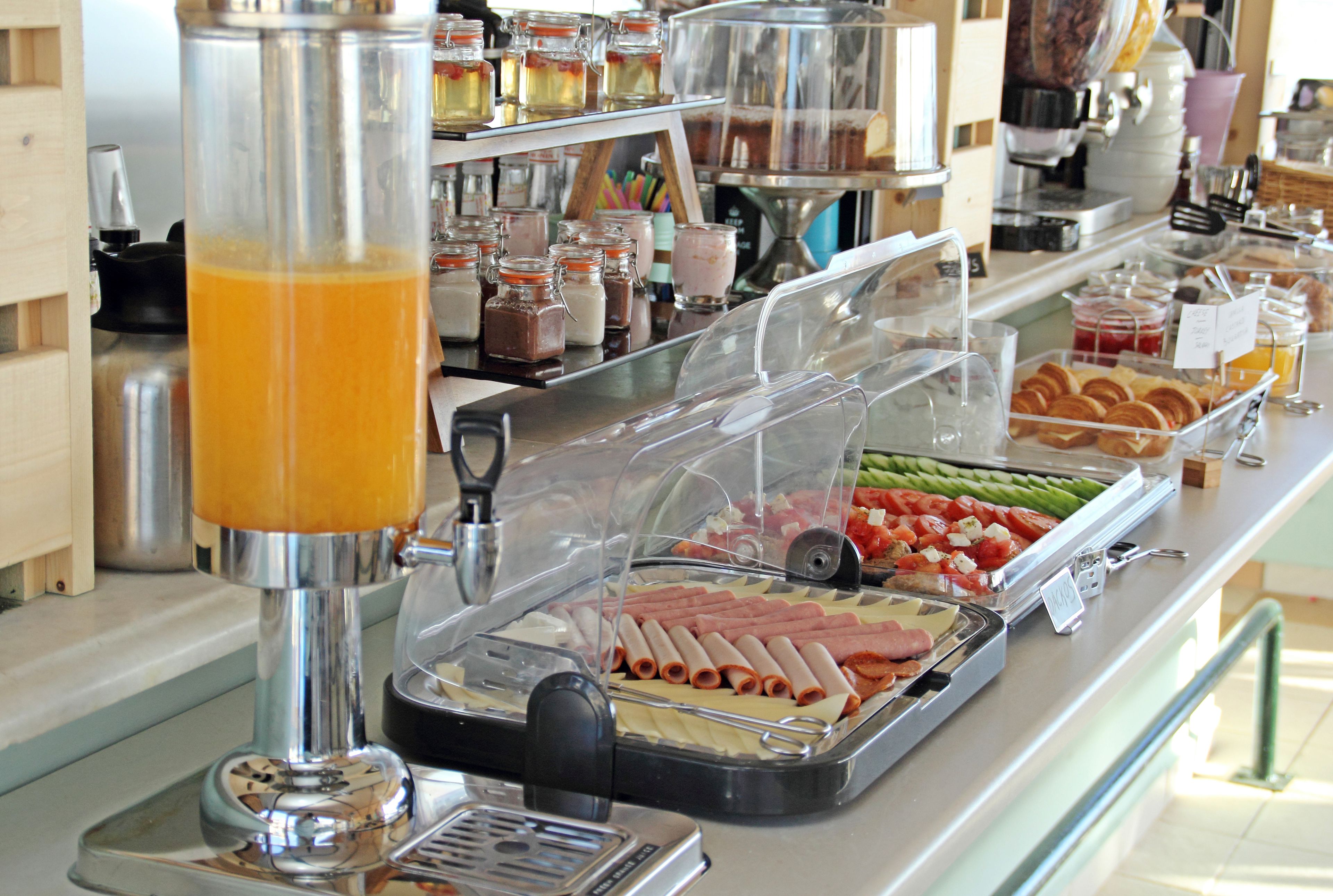 Un bufé con diversas opciones de comida y una máquina de café.