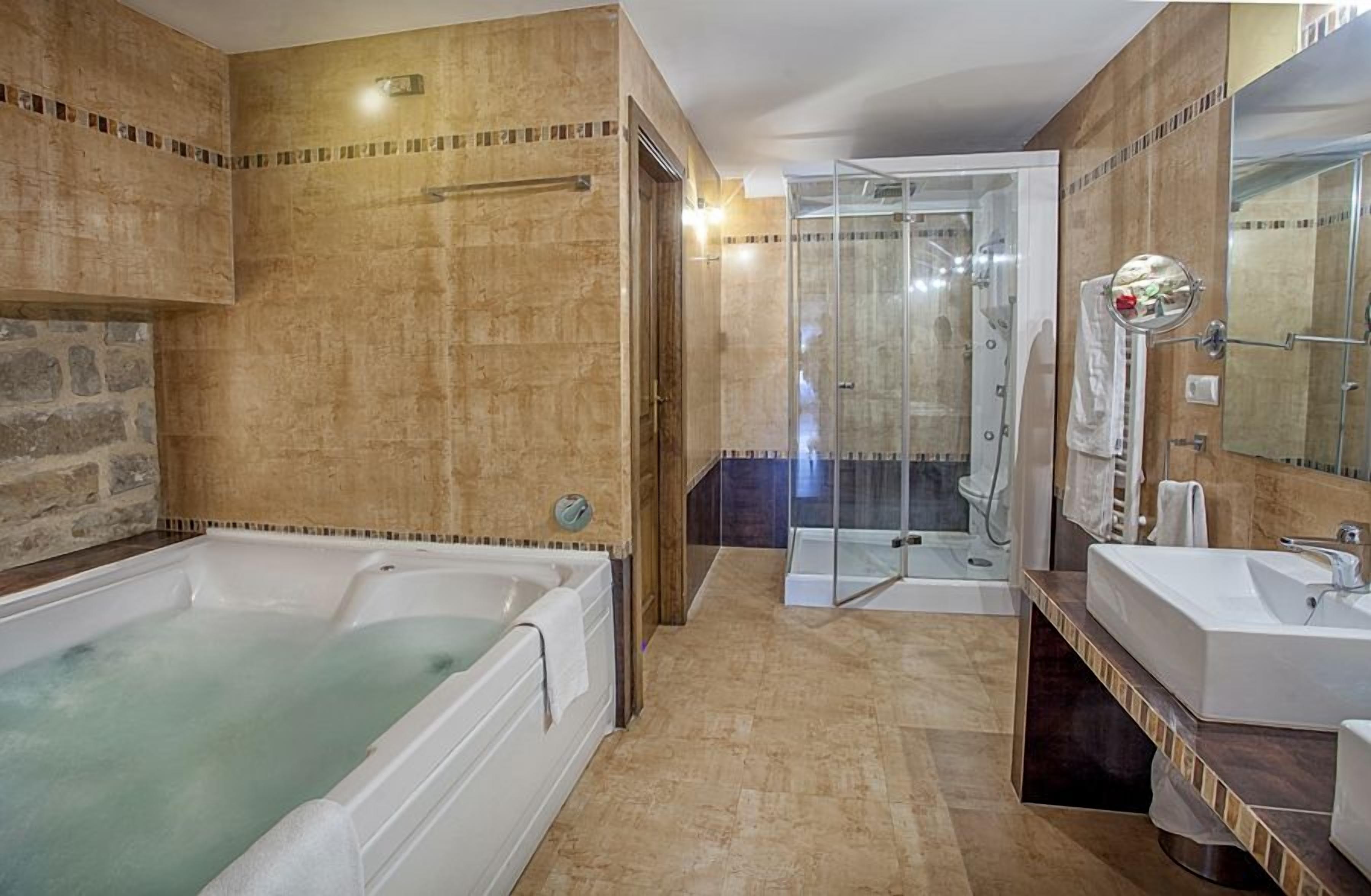 A bathroom with a bathtub, shower, and sink.