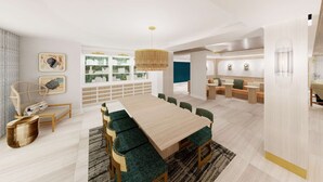 Un espace de salle à manger moderne avec une longue table en bois, des chaises à l’assise rembourrée de couleur verte et un luminaire suspendu.