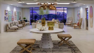 A modern living room with a round dining table, wicker furniture, and a large window with a city view.