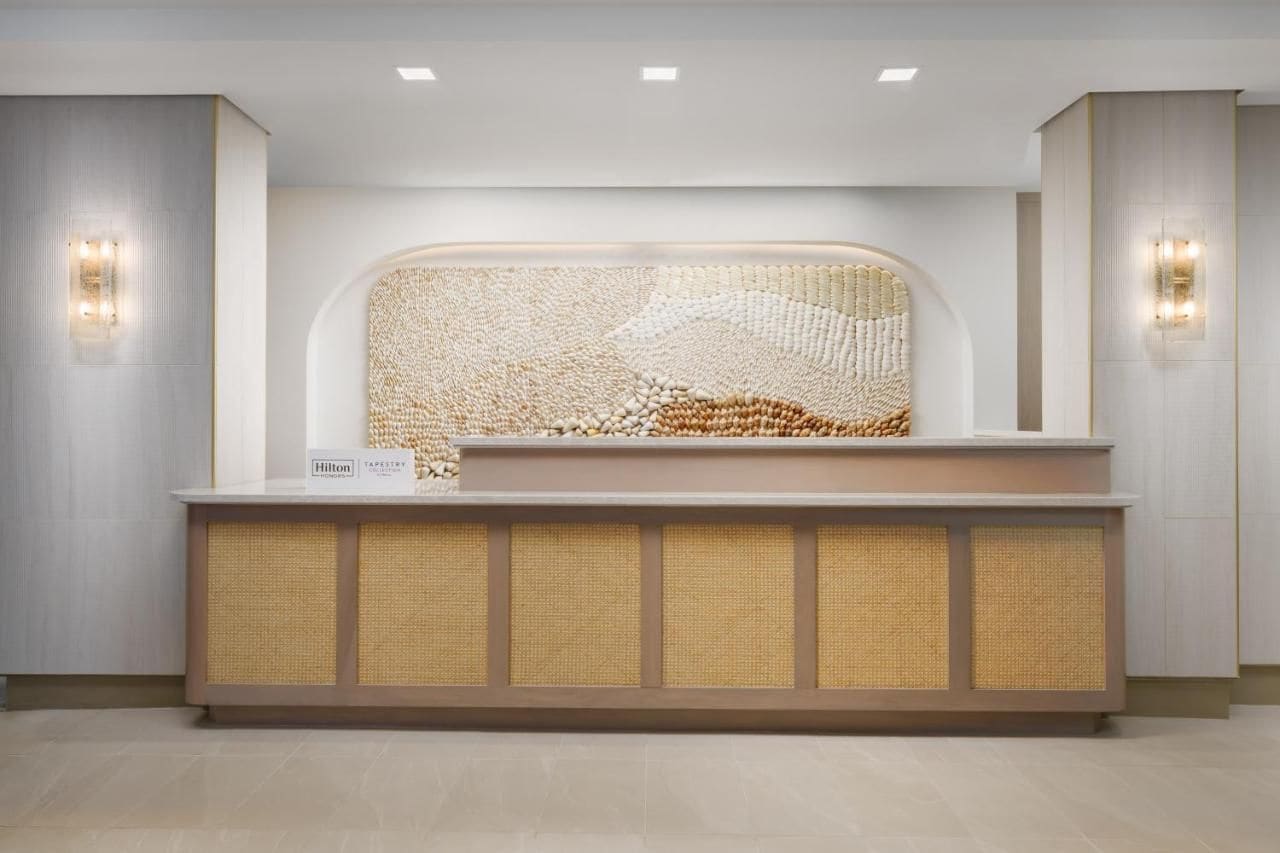 A reception desk with a woven backrest and a sign indicating it's a Hilton hotel.