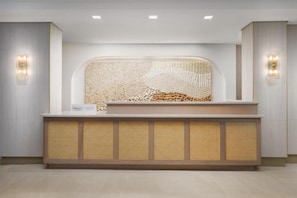 A reception desk with a woven backrest and a sign indicating it's a Hilton hotel.