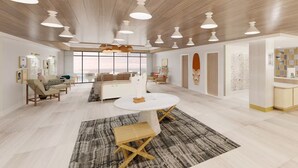 Un vaste espace de vie comprenant une table à manger ronde, un canapé et une table basse. On y trouve plusieurs luminaires suspendus et une grande fenêtre qui laisse entrer la lumière naturelle.