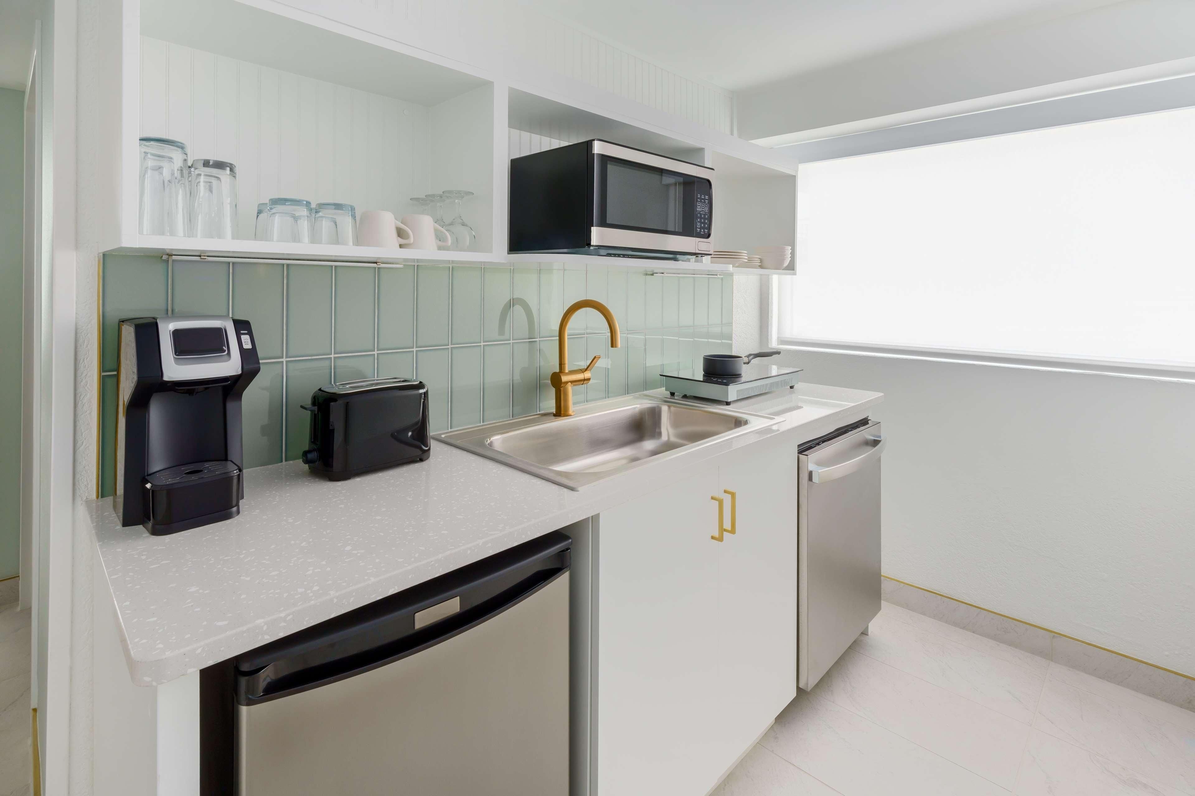 A modern kitchen with a microwave, coffee maker, and dishwasher.