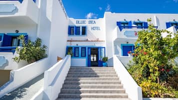 A hotel with a prominent sign reading 'BLUE SEA HOTEL' and a staircase leading to the entrance.