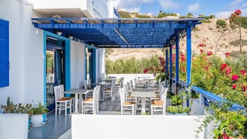 A terrace with outdoor seating, white walls, and blue accents.
