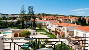 Ein Resort mit mehreren weißen Gebäuden, einem Swimmingpool und einem gepflegten Garten.