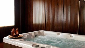 Un jacuzzi con un fondo de pared de madera, un panel de control y velas sobre una bandeja.