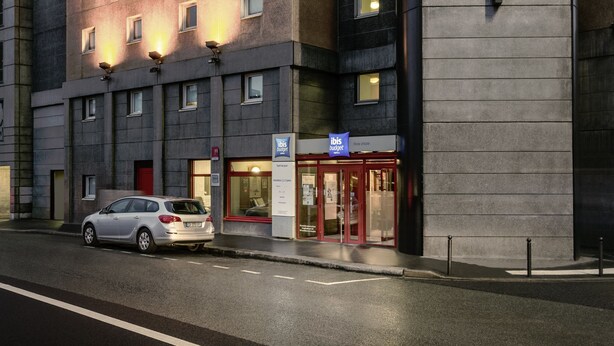A hotel with a modern facade, multiple windows, and a prominent entrance with a red door. - ibis budget Paris Porte d'Italie Est (Le Kremlin-Bicetre)