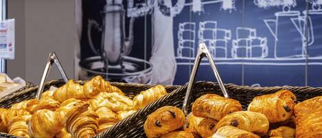 Une variété de pâtisseries présentées dans des paniers, avec une pancarte indiquant « BUFFET » en arrière-plan.