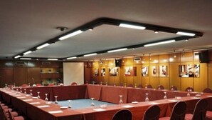 A conference room with a long table, chairs, and a projector screen. - Condes de Urgel (Lleida)