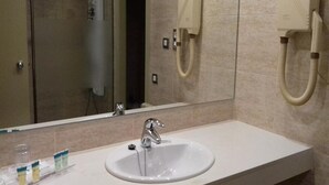 A bathroom with a sink, mirror, and towel dispenser. - Condes de Urgel (Lleida)