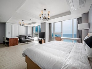 A modern hotel room with a large bed, a desk, a sofa, and a TV. - Haeundae Seacloud Hotel Residence (Busan)
