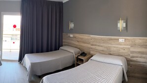 A hotel room with two beds, a wooden headboard, a nightstand with a phone, and a view of the outside. - Reymar Playa (Malgrat de Mar)