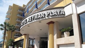The exterior of the Hotel Reymar Playa, featuring a modern design with a prominent entrance, a staircase leading to the lobby, and a balcony with potted plants. - Reymar Playa (Malgrat de Mar)