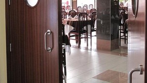 A hotel room with a wooden door, a round mirror, and a view of a dining area with tables and chairs. - Reymar Playa (Malgrat de Mar)