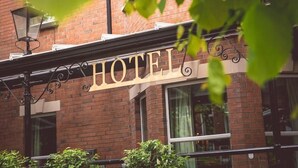 Une enseigne d’hôtel avec le mot « HÔTEL » écrit en grandes lettres sur un bâtiment en briques.