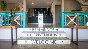 A reception area with a staircase, a reception desk, and a sign that reads "BEM VINDOS BIENVENIDOS WELCOME". - Pousada Aroma do Mar (Búzios)