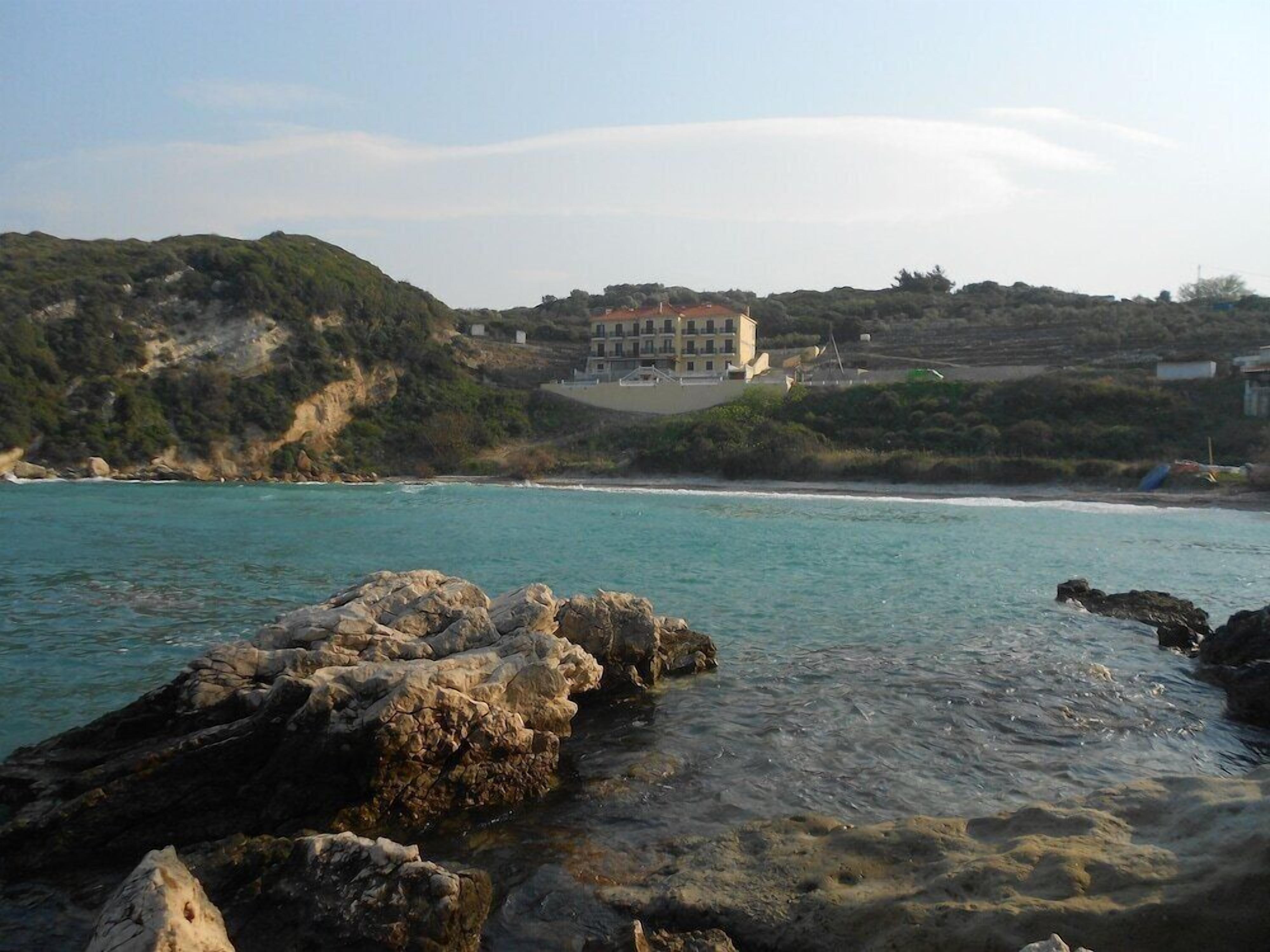 Une propriété située sur la côte, avec un grand bâtiment dominant la mer, un littoral rocheux et un terrain vallonné.