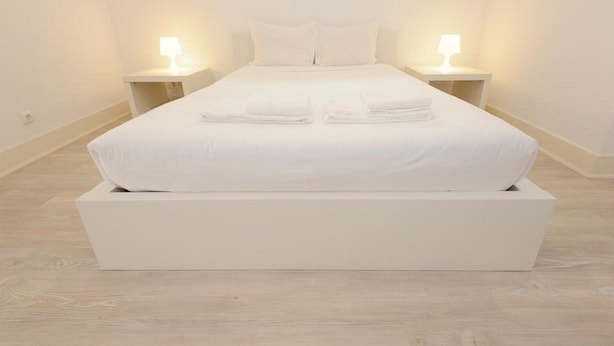 A large bed with white linens and two bedside tables with lamps. - Portugal Ways Lisbon City Apartments (Lisbon)