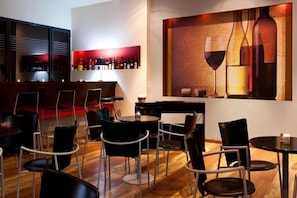 Un espace bar moderne avec un présentoir à vin et des sièges.