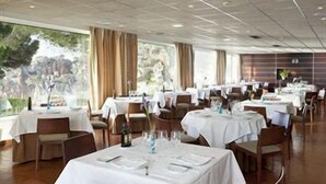 Un restaurante con varias mesas, manteles blancos y sillas.