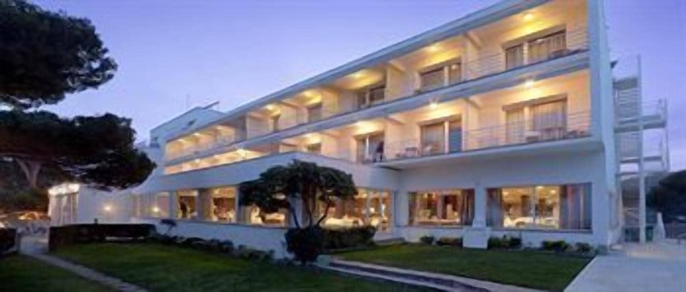 Un hotel de varios pisos con balcones y fachada iluminada.