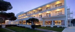 A multi-story hotel with balconies and a well-lit exterior. - Parador de Aiguablava (Begur)