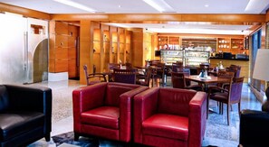 A hotel lobby with leather armchairs, a bar area, and a reception desk. - Golden Sands Hotel Apartments (Dubai)