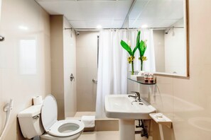 Un baño moderno con inodoro, lavamanos y cortina de ducha.