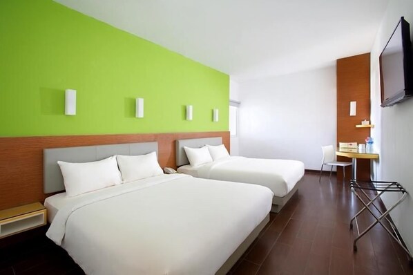A hotel room with two beds, a desk, a chair, a TV, and a wall-mounted TV. - Amaris Hotel Tebet (Jakarta)