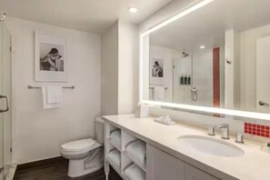 Une salle de bain moderne avec un grand miroir, un lavabo blanc et des toilettes.