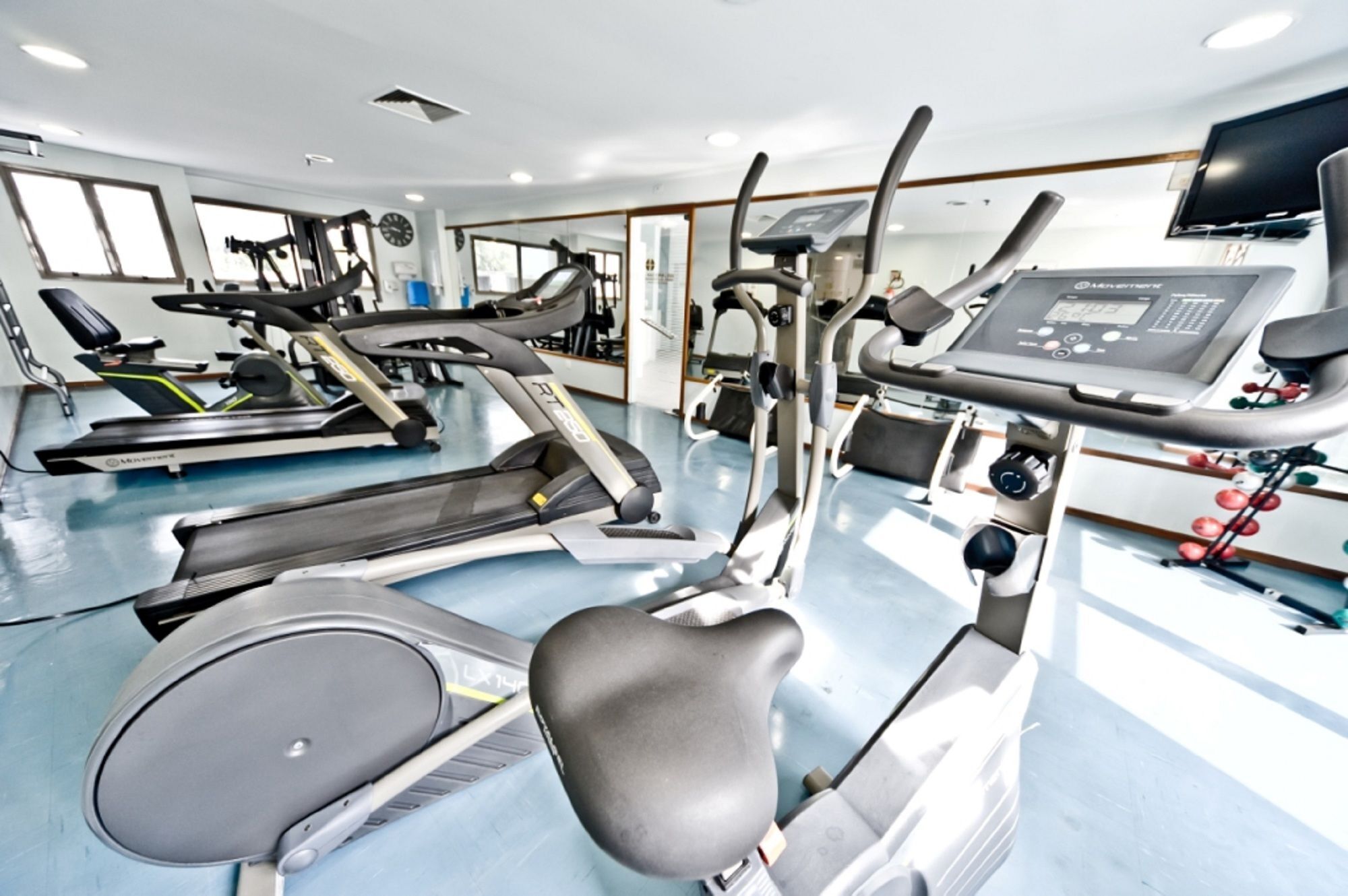 Academia com esteiras, elípticos e equipamentos de musculação.