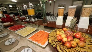 A buffet with various food items including fruits, vegetables, and beverages.
