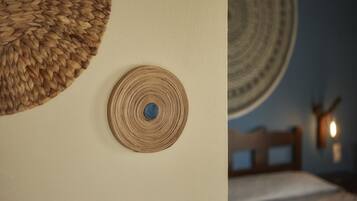 Una habitación con una cama, un tapiz de pared tejido y una decoración circular en la pared.