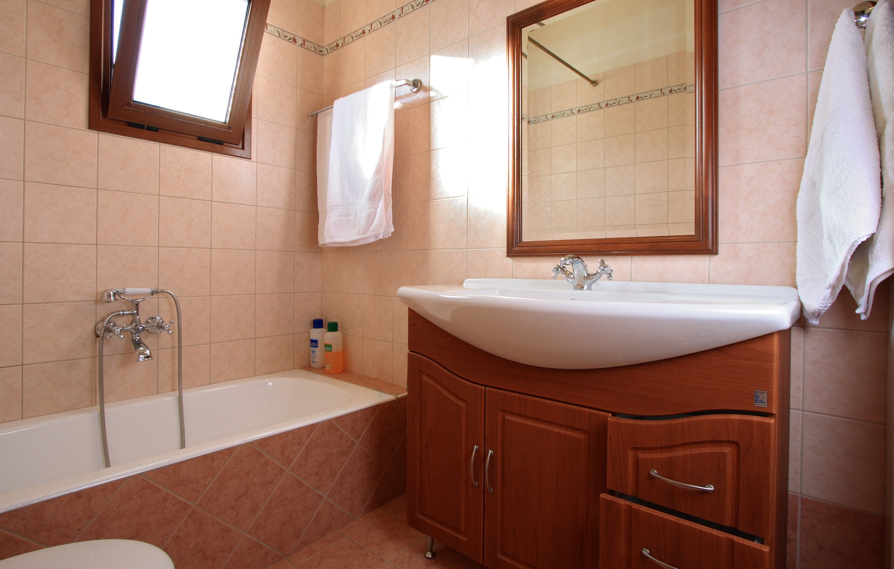 A bathroom with a bathtub, a sink, and a mirror.