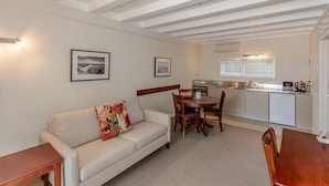 A compact living space with a sofa, a dining table, and a kitchenette. - The Parnell Hotel and Conference Centre (Auckland)