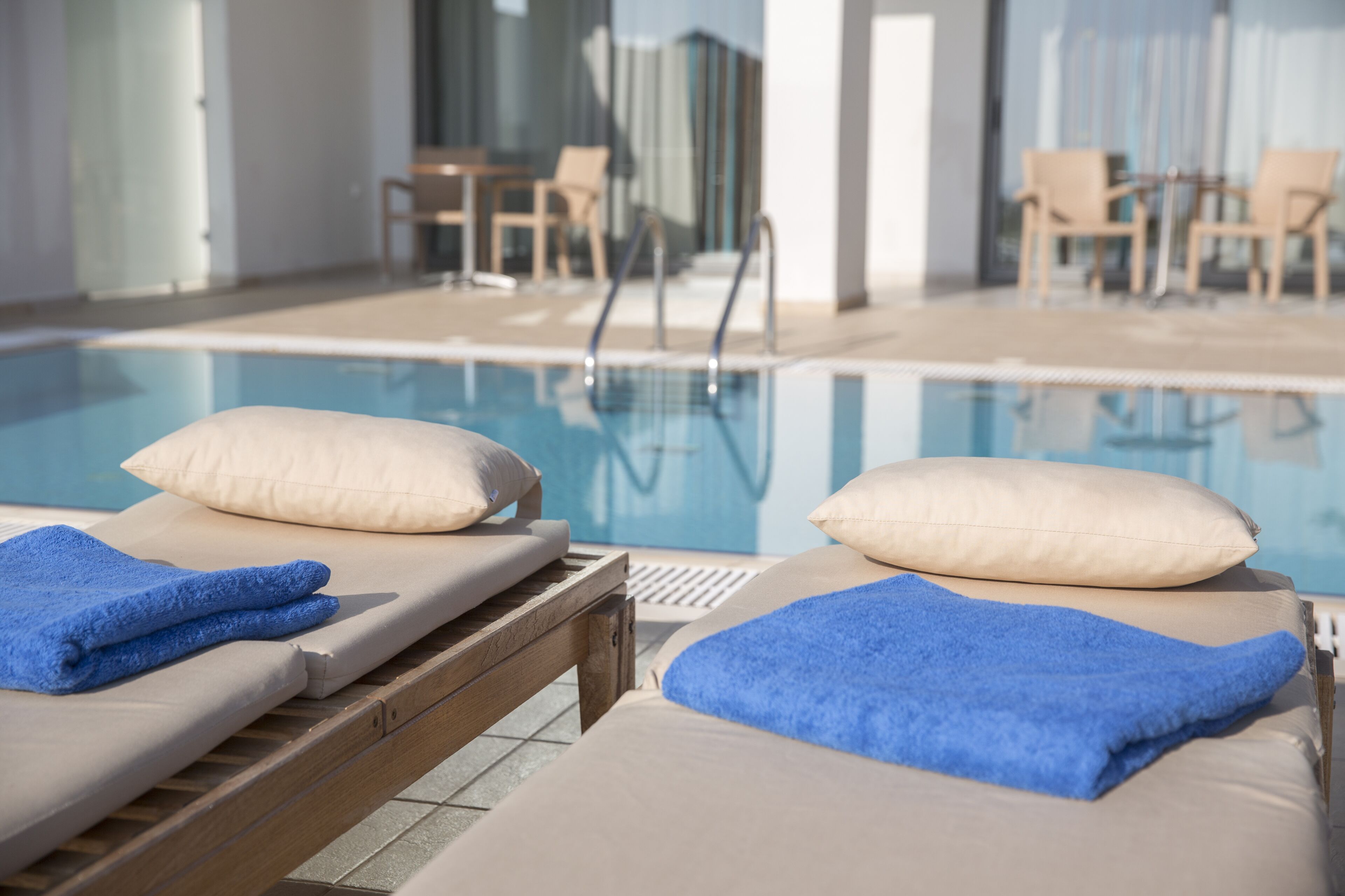 Zona de piscina con sillones reclinables y una pileta.