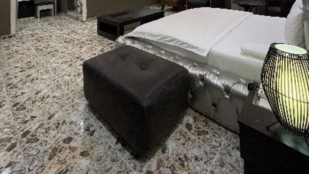 A modern bedroom with a large bed, a desk, and a TV. - Charlie's Place And Suite (Lagos)