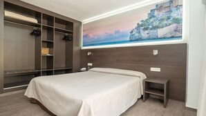 A bedroom with a bed, a nightstand, a built-in wardrobe, and a large window with a painting of a coastal scene.