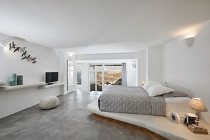 Un dormitorio moderno con una cama grande, un televisor y vistas al exterior.