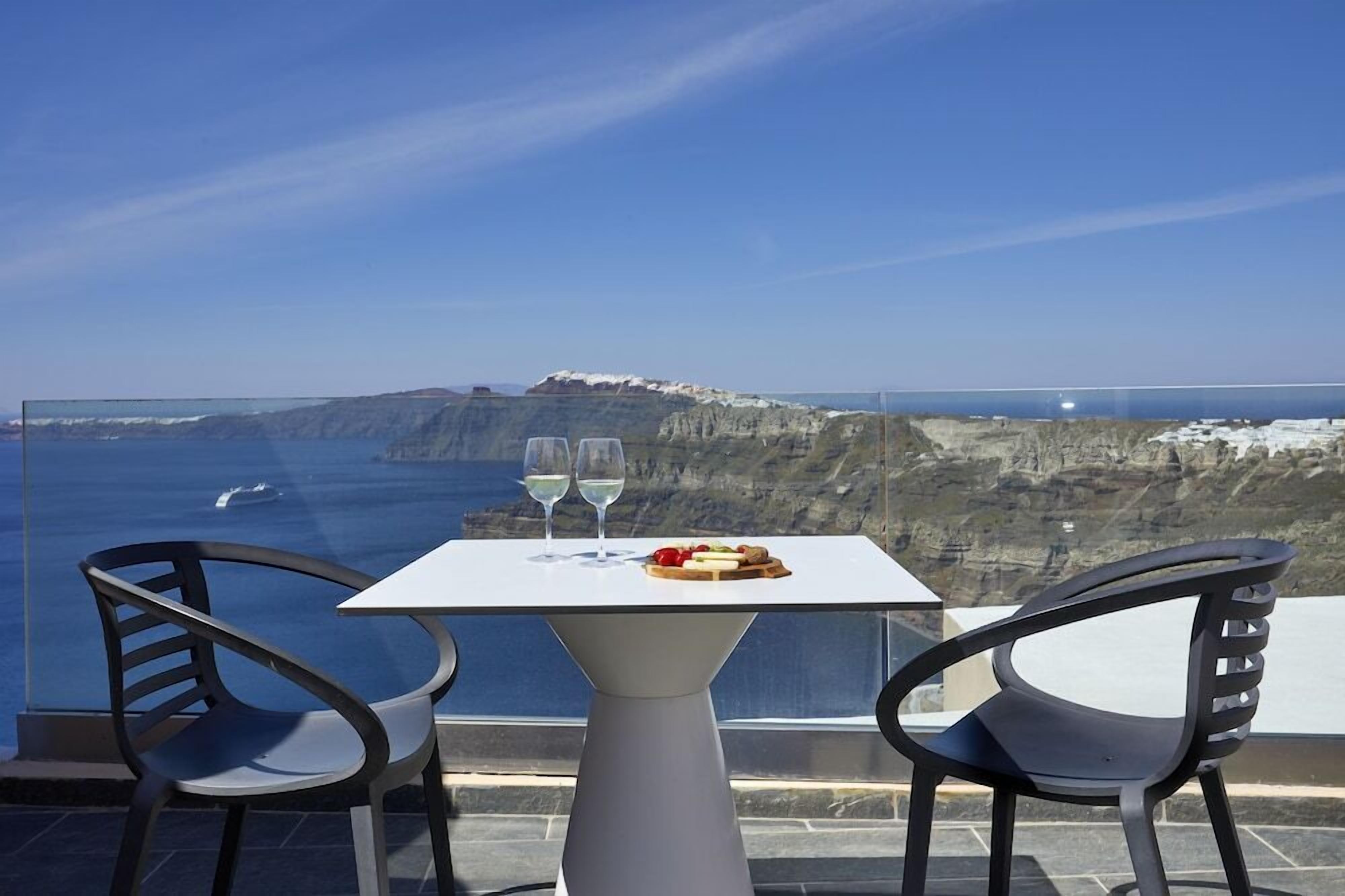 A table with two chairs overlooking a scenic coastal view.